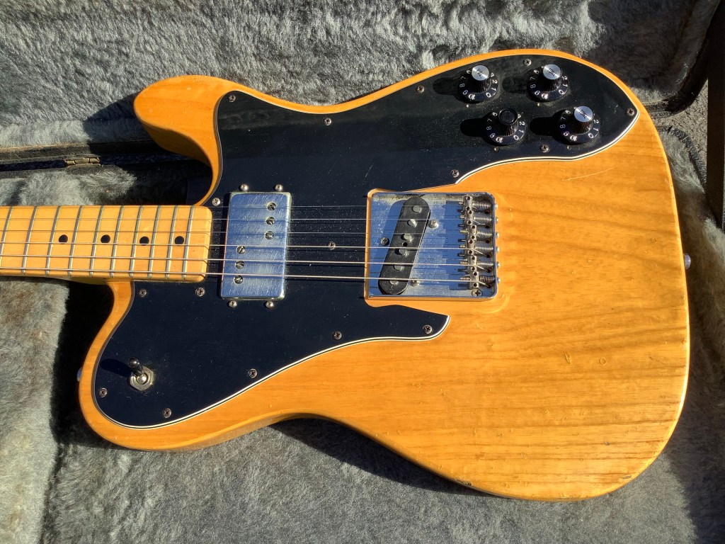 Natural wood Fender Telecaster Custom Deluxe with factory fitted humbucker and single coil bridge pickup, showing vintage wear and autographs on the back.
